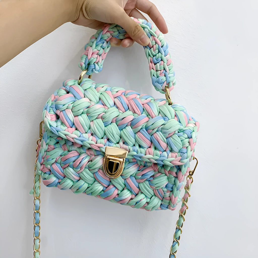 Hand knitted crochet tote crossbody bag in cotton with lock closure, yellow colour, on a plain background