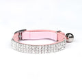 Close-up of a red velvet cat collar with rhinestone decoration, showing the adjustable buckle.
