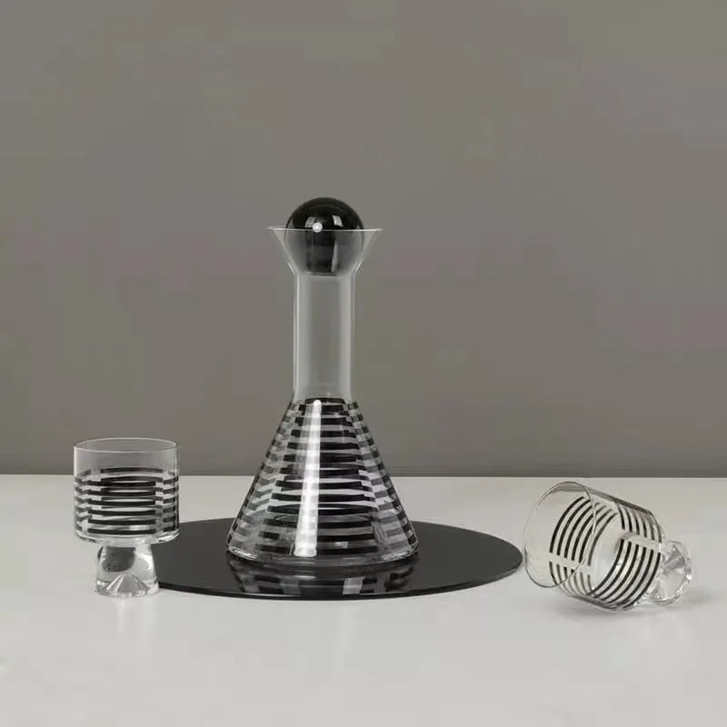 Modern black striped glass cold water bottle 1000ml with two cups on a light surface