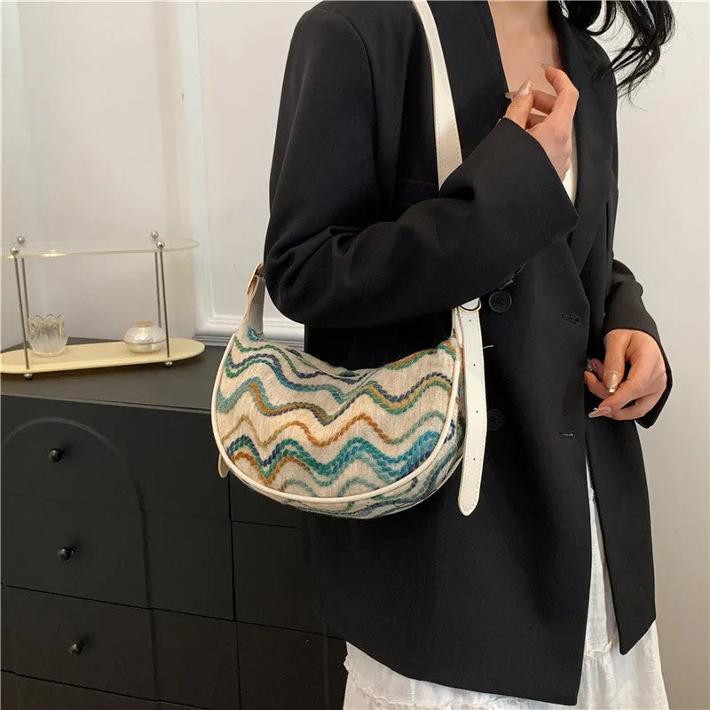 Women's woven straw crossbody bag showing internal phone pocket and file compartment in corrugated black colour