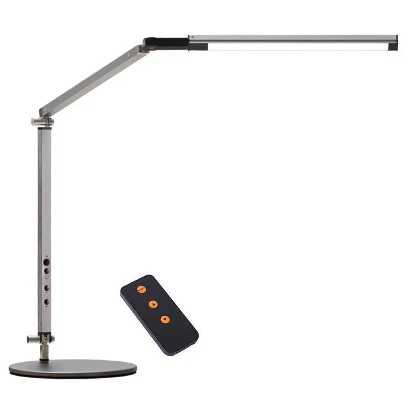 Aluminium clip-on desk lamp with adjustable arm and remote control on a wooden desk.