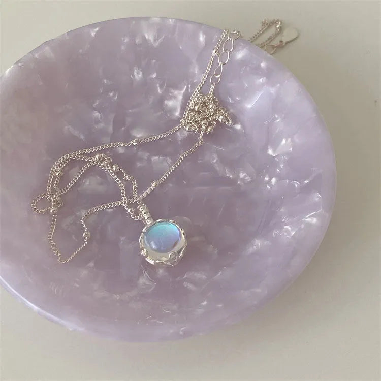 Silver necklace with geometric stone pendant on an adjustable curb chain.