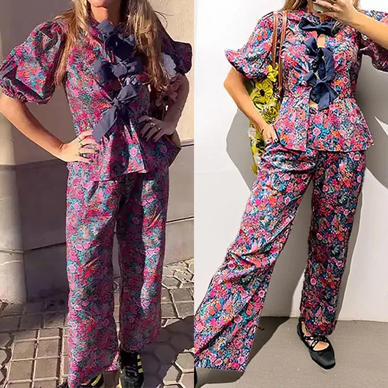 Women's floral printed trousers suit with tie-neck puff sleeve top and matching trousers in polyester fabric
