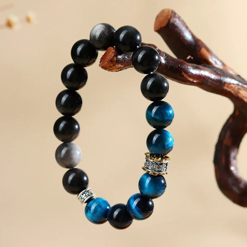 Handmade geometric Peacock Blue Tigereye stone bracelet with round beads on a wrist.
