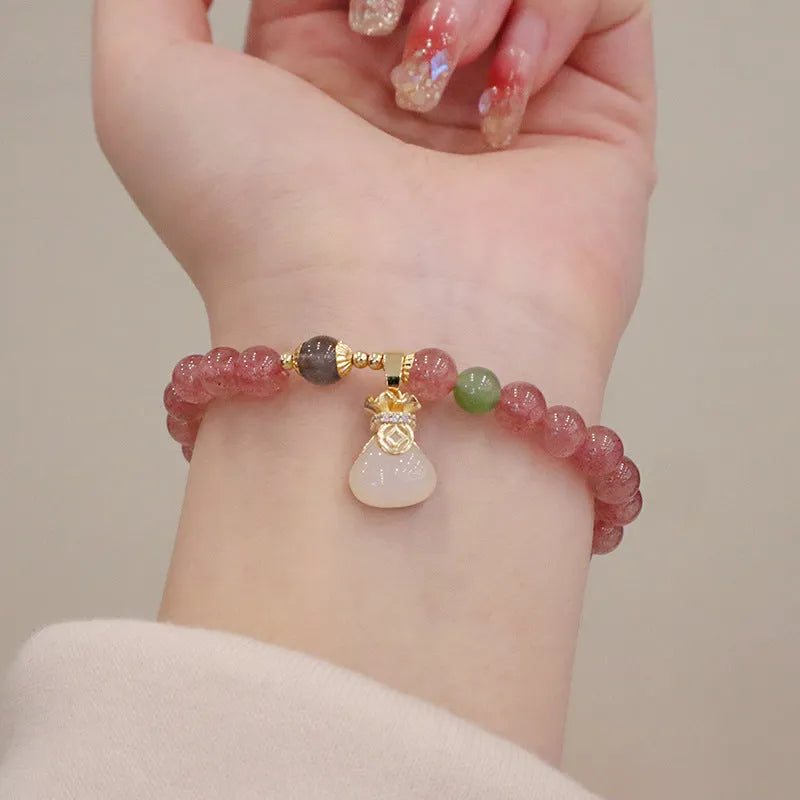 Natural strawberry quartz women's bracelet with geometric design, peace buckle closure, and lucky bagg purse charm attachment