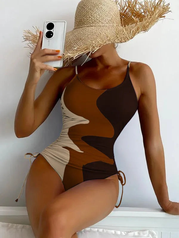 Women's sleeveless one-piece swimsuit in blue, shown from the front, with a backless design and striped pattern.