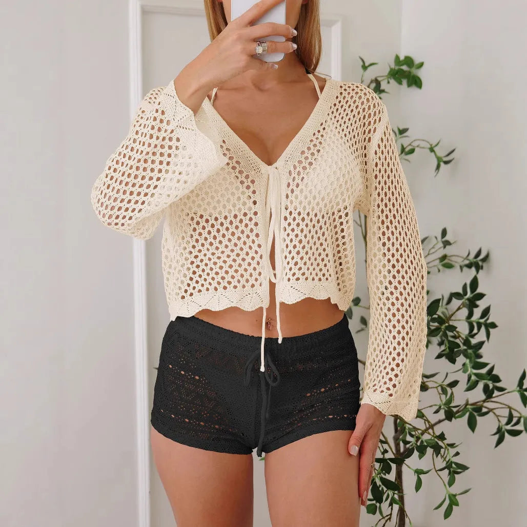 Short apricot hollow woven women's cardigan blouse with bell sleeves on a hanger