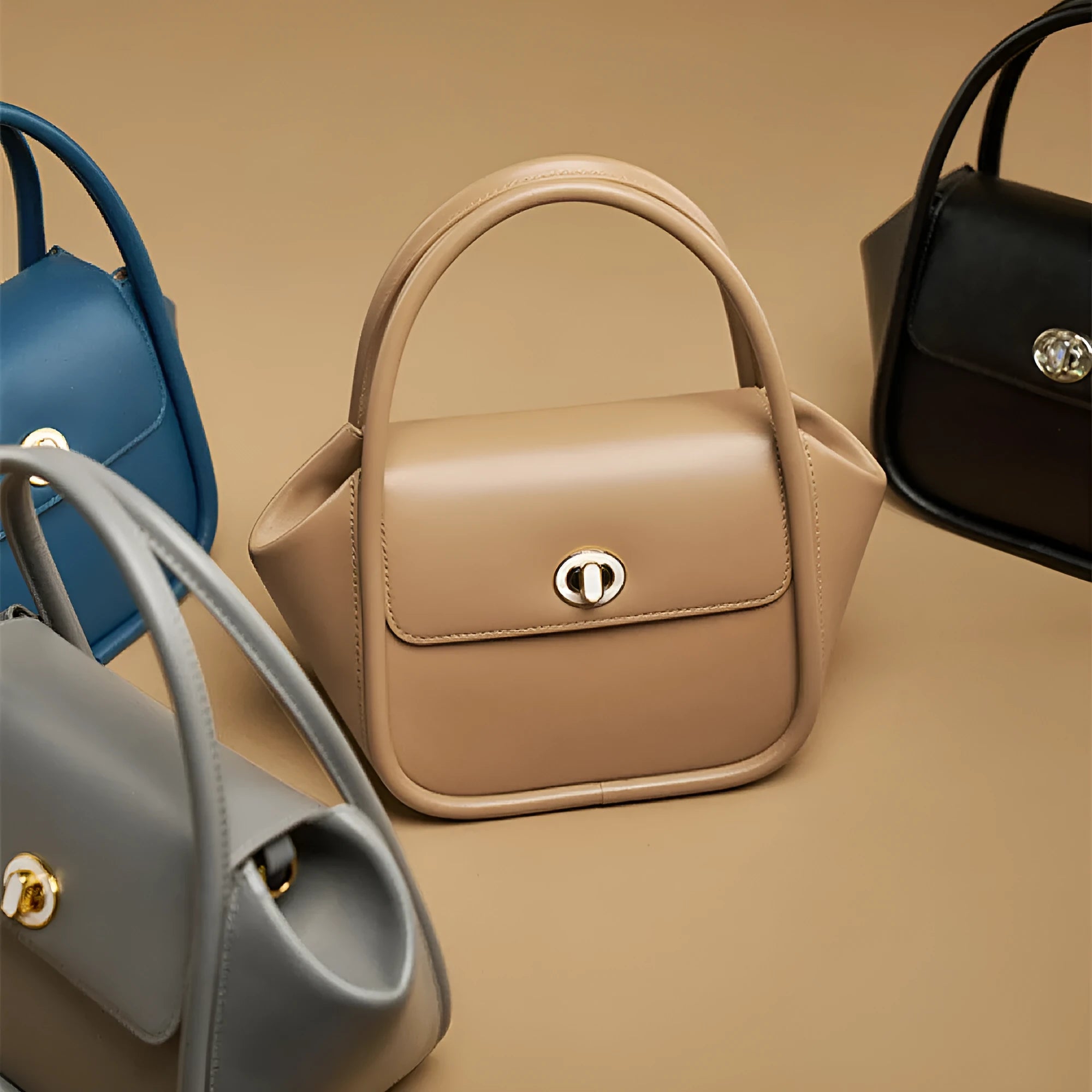 Women's wing-shaped leather tote bag with a latch buckle, shown in Atlantic blue with a cross-body strap.
