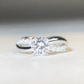 Geometric twist arm silver ring with 1 karat moissanite stone in four-claw winding setting