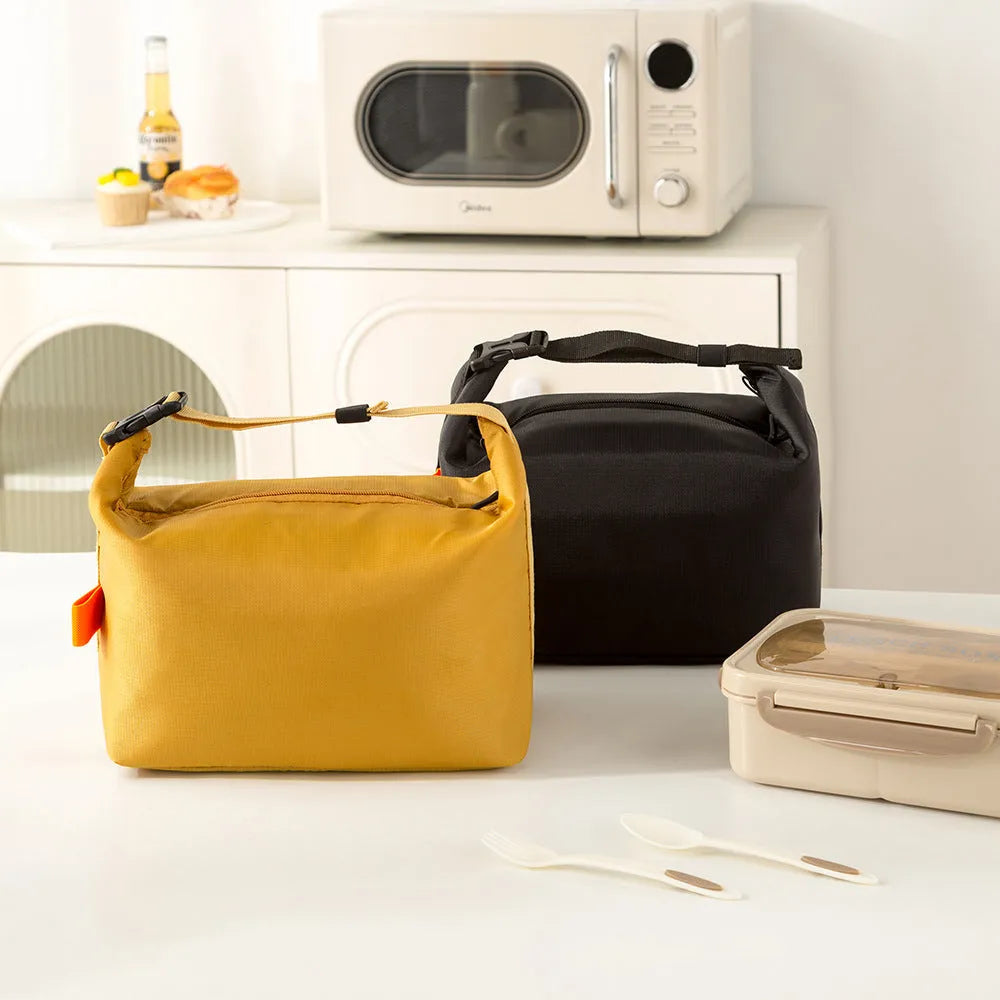 Japanese style insulated lunch bag in Oxford cloth shown in one of four colours: Army Green, Black, Grey, or Yellow.