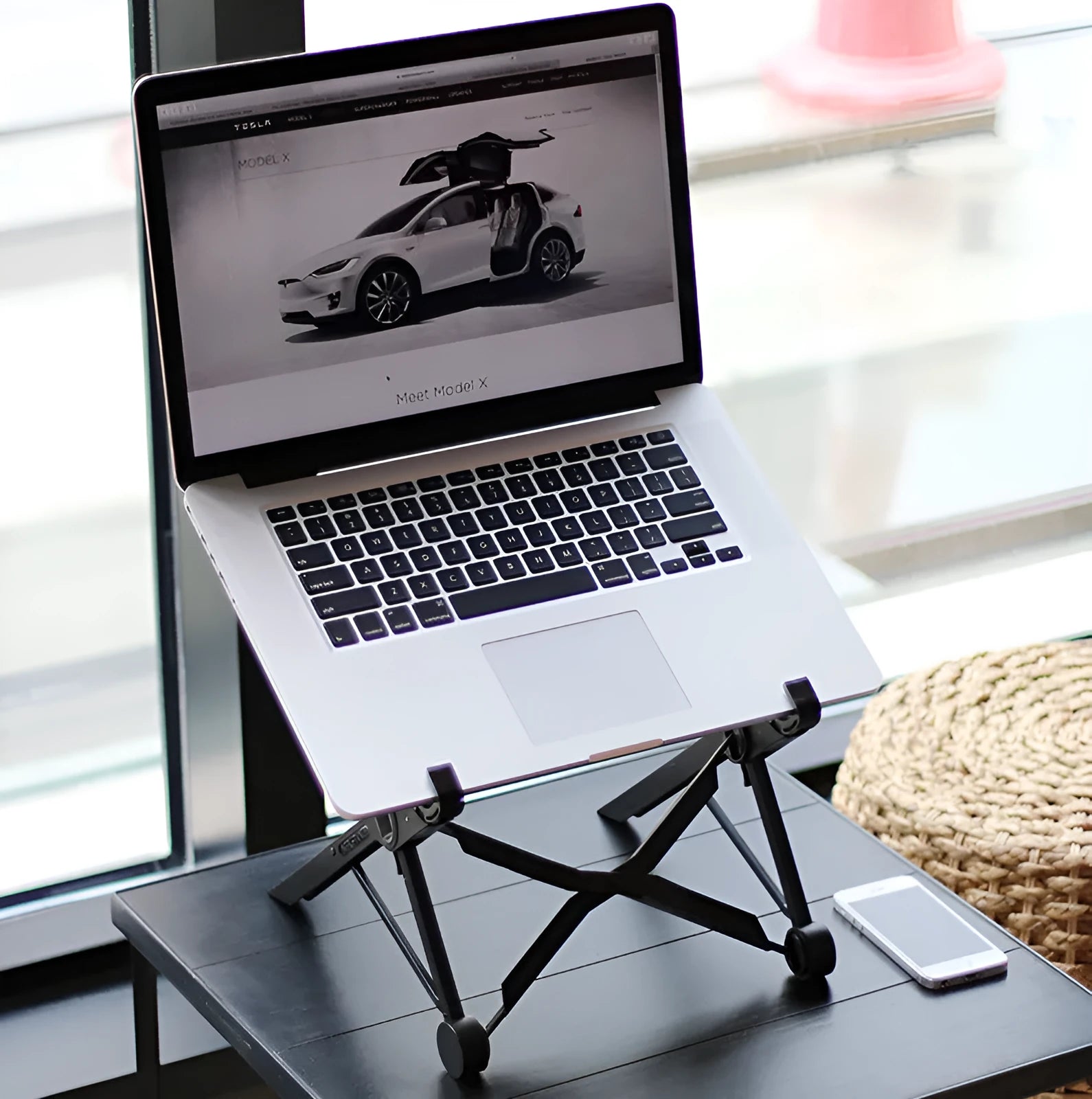 Black folding laptop stand showing folded and unfolded positions with reinforced nylon construction
