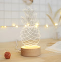 Cartoon pineapple shaped table lamp with wood and acrylic construction on a white background.