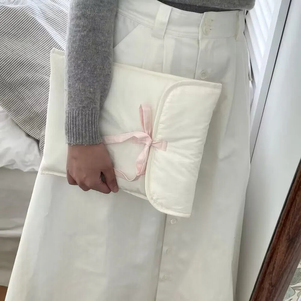 Women's black and white quilted ballet style laptop bag with bow, shown in two sizes.
