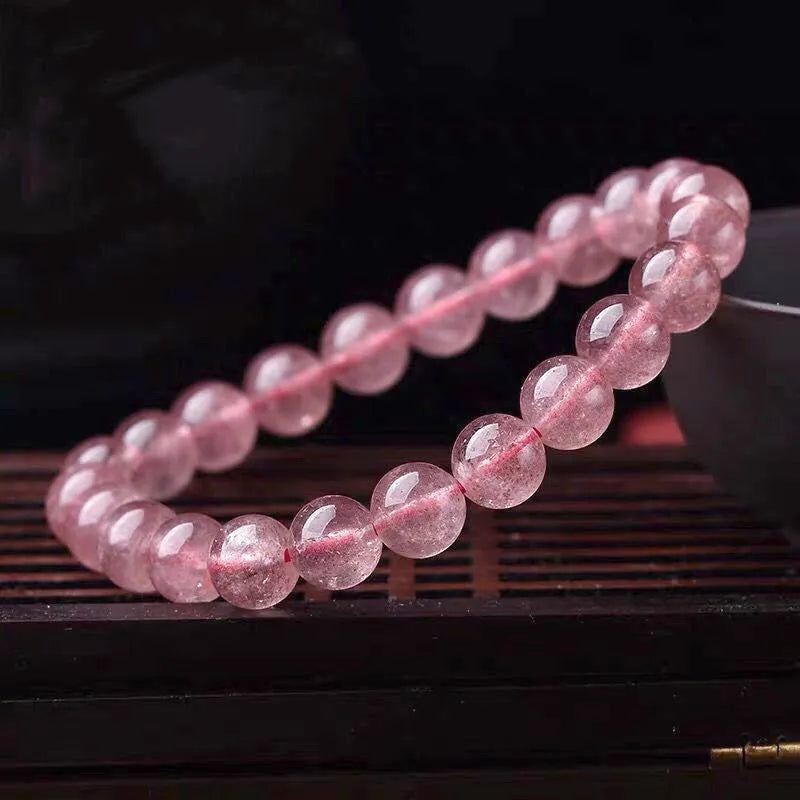 Women's strawberry quartz bracelet with polished beads in 6mm, 8mm, or 10mm sizes on adjustable knot.