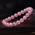 Women's strawberry quartz bracelet with polished beads in 6mm, 8mm, or 10mm sizes on adjustable knot.