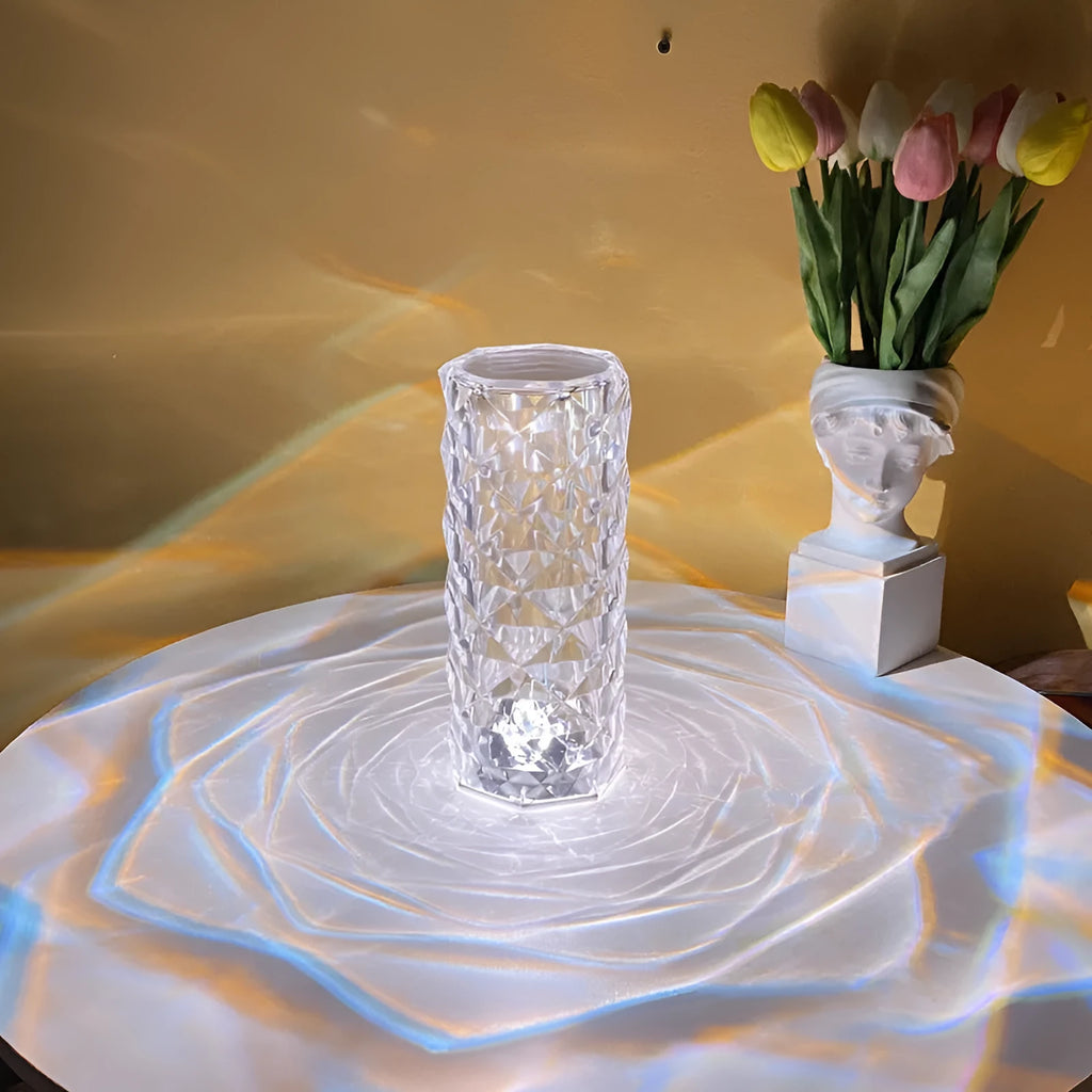 LED rose diamond shaped table lamp with acrylic construction and three-tone lighting on a wooden surface.