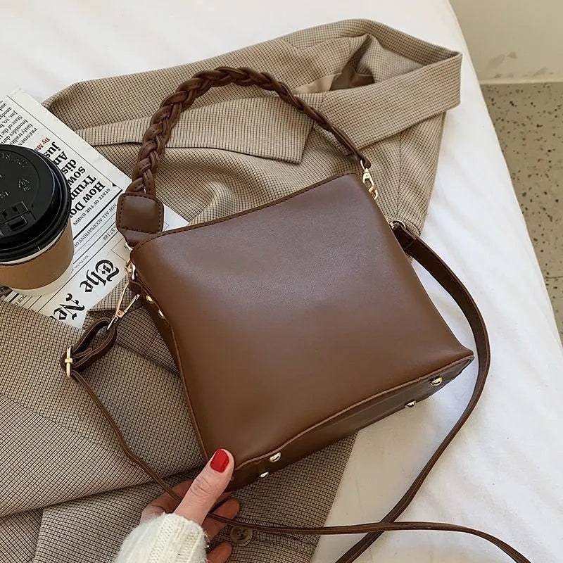 Khaki PU leather bucket bag with woven texture and a crossbody strap.