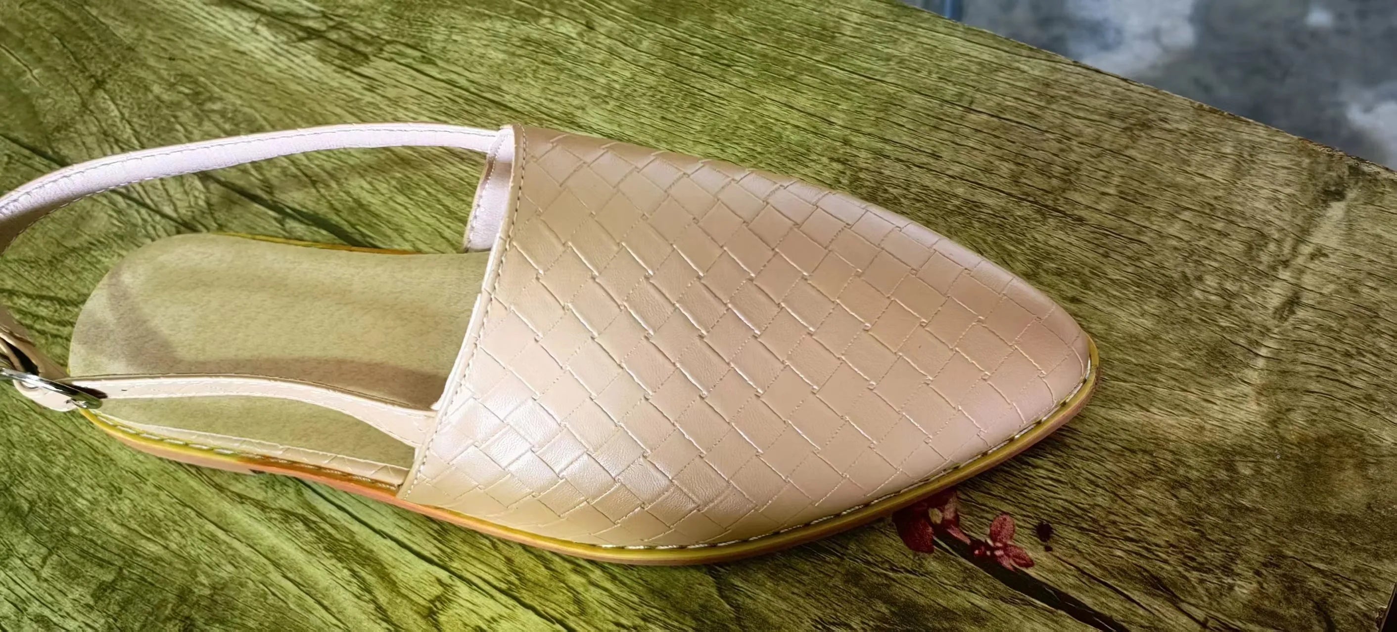 Flat pointed toe sandals with a silver buckle on a microfiber upper.