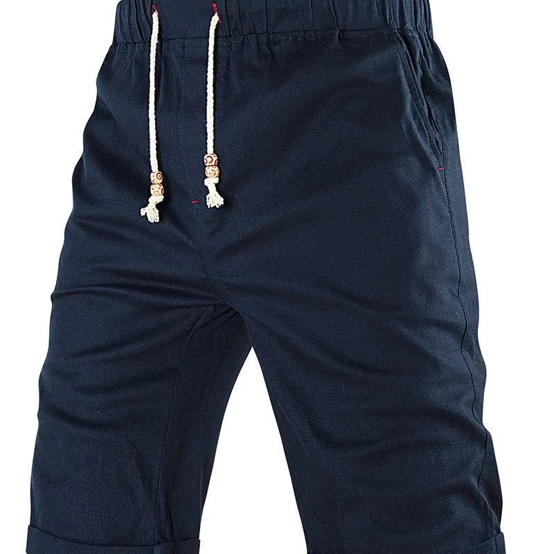 Man wearing grey cotton blend straight leg sports shorts with a drawstring waist and a zipper side pocket.