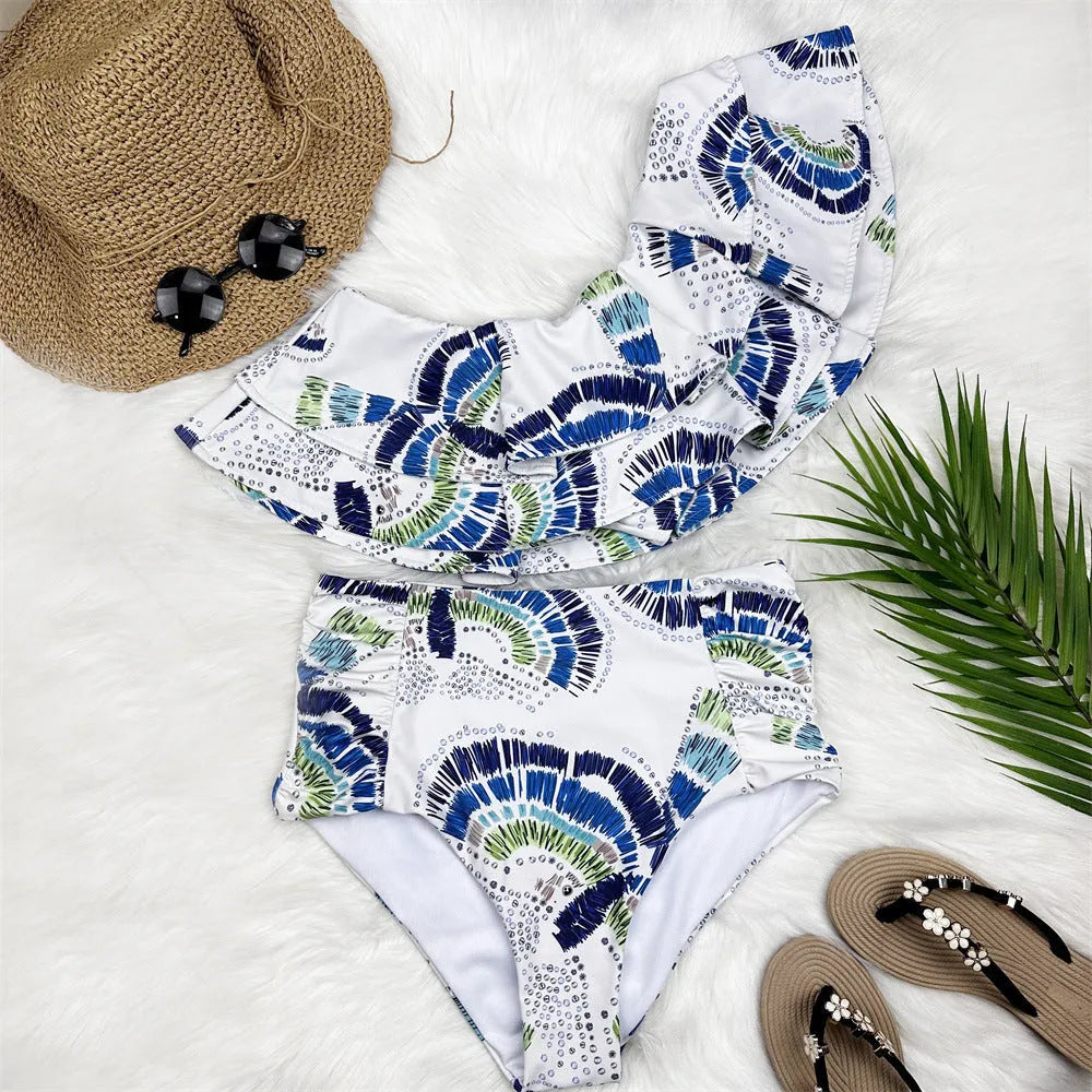 White women's one-shoulder bikini with lotus leaf detail and high-leg split bottom.