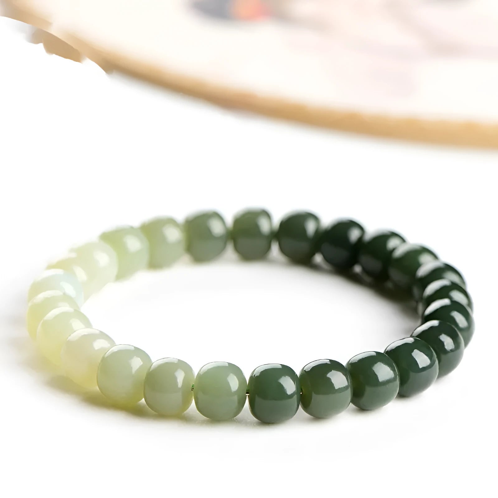 Hetian Jade bracelet with water gradient colours showing polished beads in natural stone