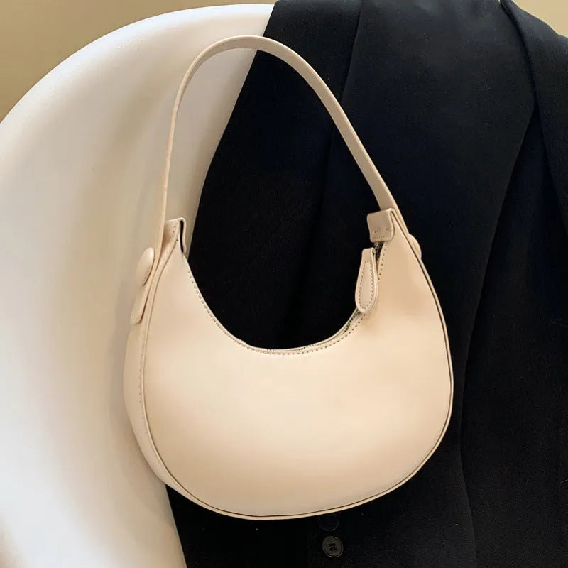 Retro dumpling-shaped black PU leather women's shoulder bag with a front sandwich pocket.