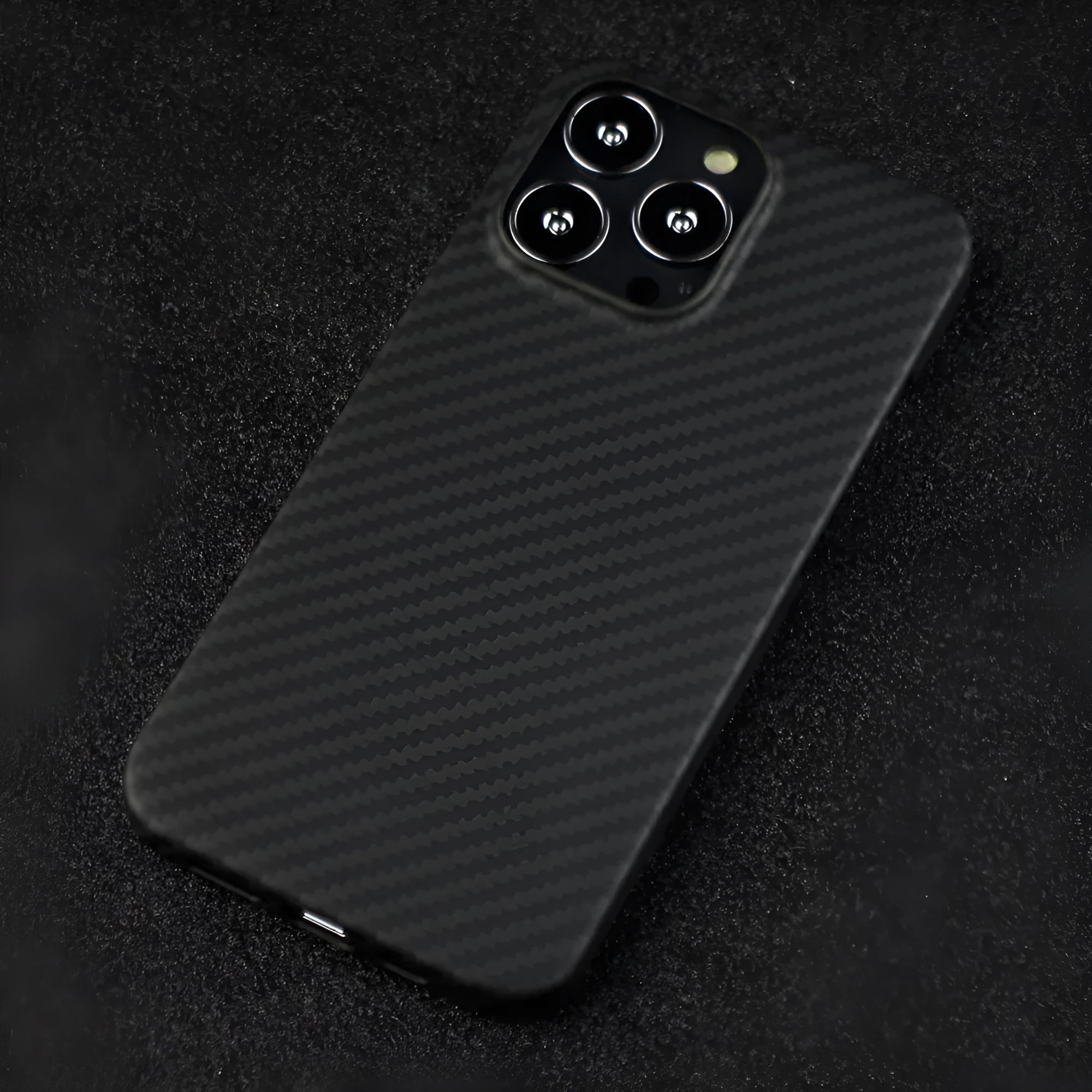 Matte black real carbon Kevlar fibre protective case for Apple iPhone, showing crater texture detail.