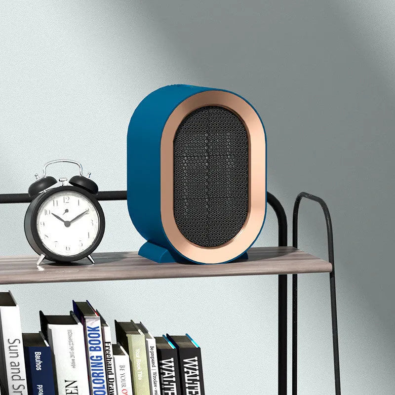 Desktop electric ceramic heater in black on a wooden desk