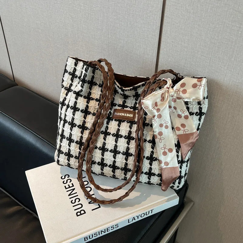 A black woven wool horizontal square shoulder bag showing external sandwich pocket and internal organiser compartments.
