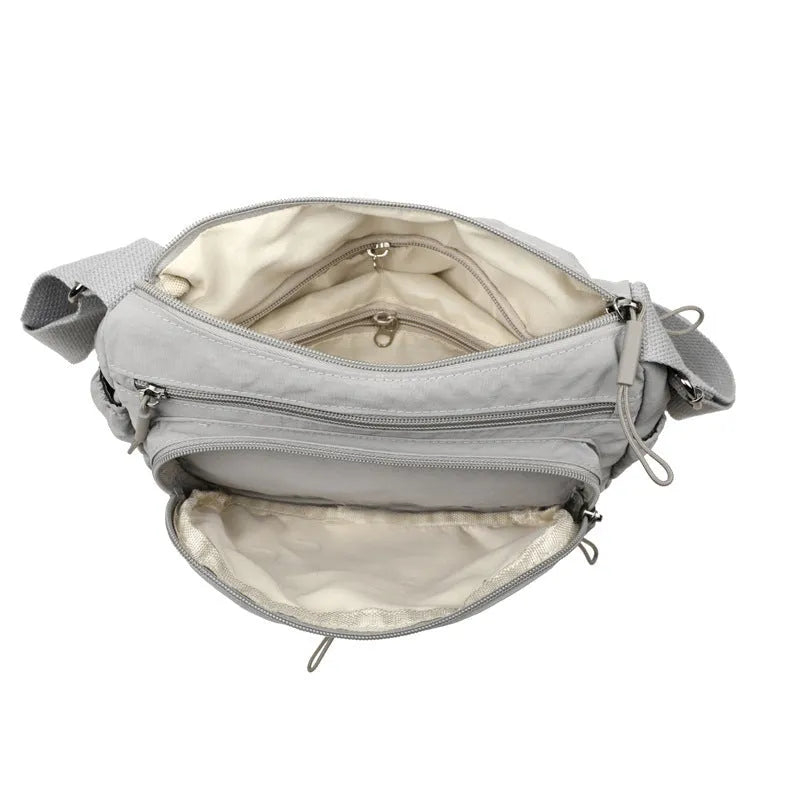 Water-repellent nylon crossbody bag with three-dimensional pockets in grey, black or red options