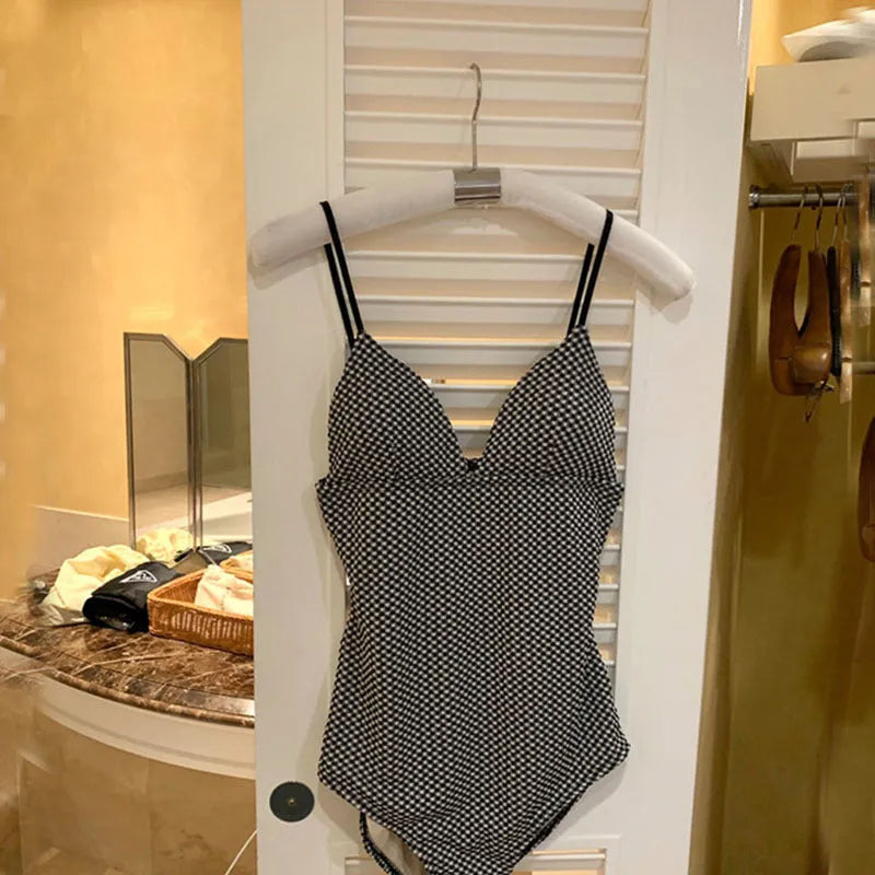 Blue one-piece swimsuit on a hanger showing belly coverage and straps for smaller chests.