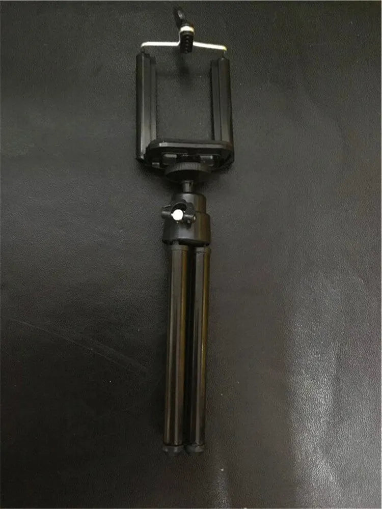 Black and silver desktop phone holder with an adjustable two-section bracket on a wooden desk.