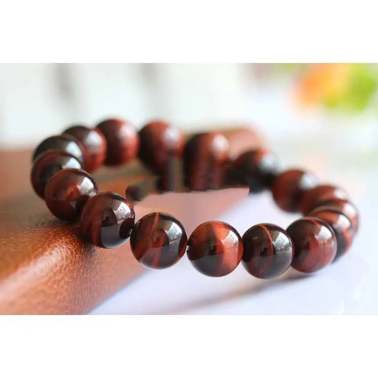 Red Tigereye wood alexandrite hand bracelet showing lightning cat's eye pattern with geometric ethnic style design