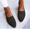 Flat pointed toe sandals with a silver buckle on a microfiber upper.