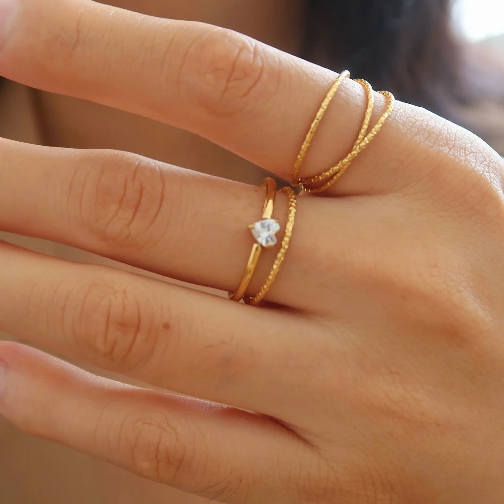 Golden heart-shaped stainless steel ring on a white background, showing its simple bracelet design and electroplated finish.