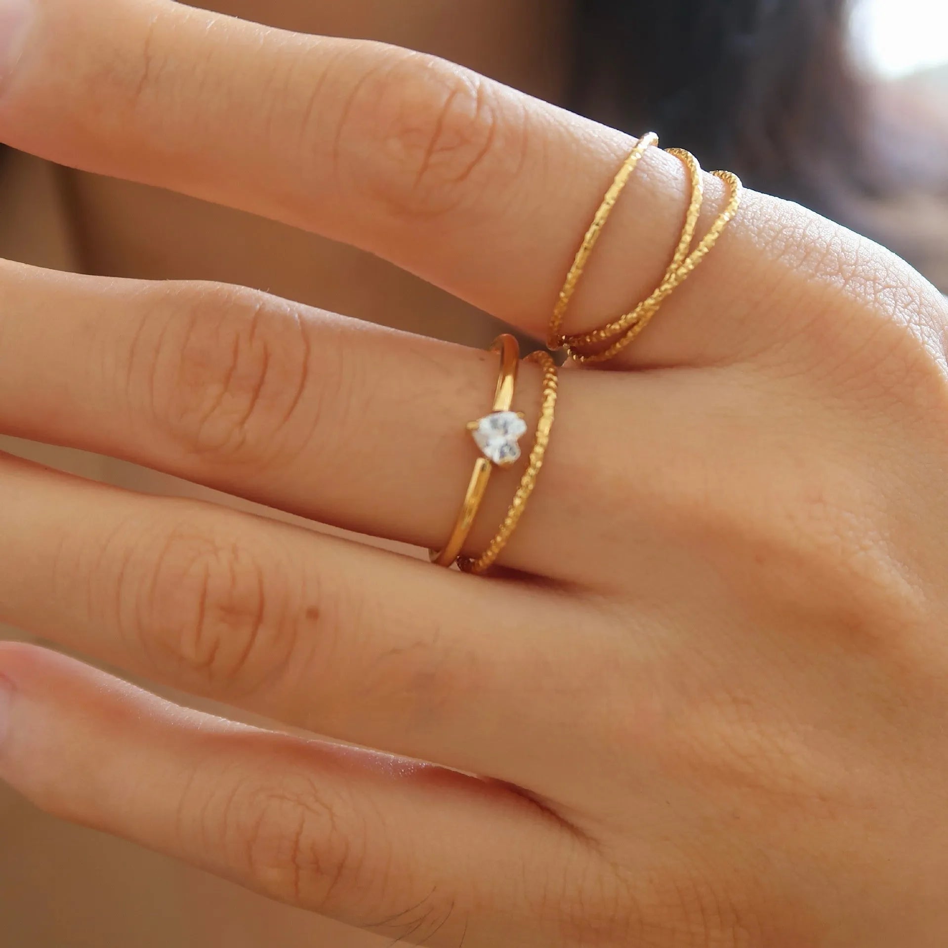 Golden heart-shaped stainless steel ring on a white background, showing its simple bracelet design and electroplated finish.