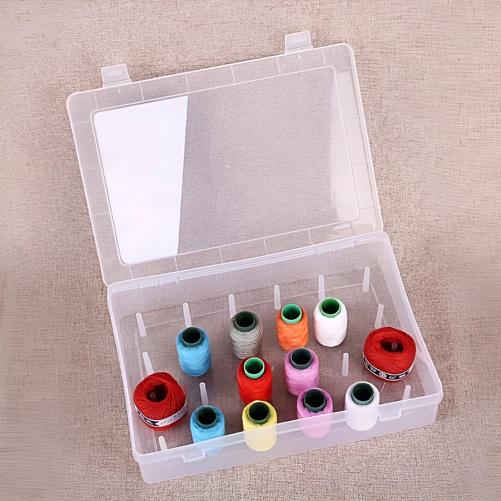 Plastic sewing storage box with 42 compartments for threads, in transparent, pink, or blue.