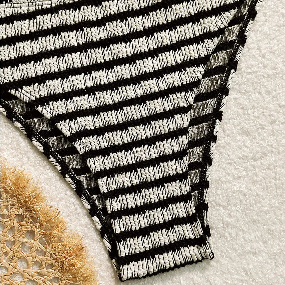 Women's pink and black striped bikini swimsuit with briefs style on a mannequin.