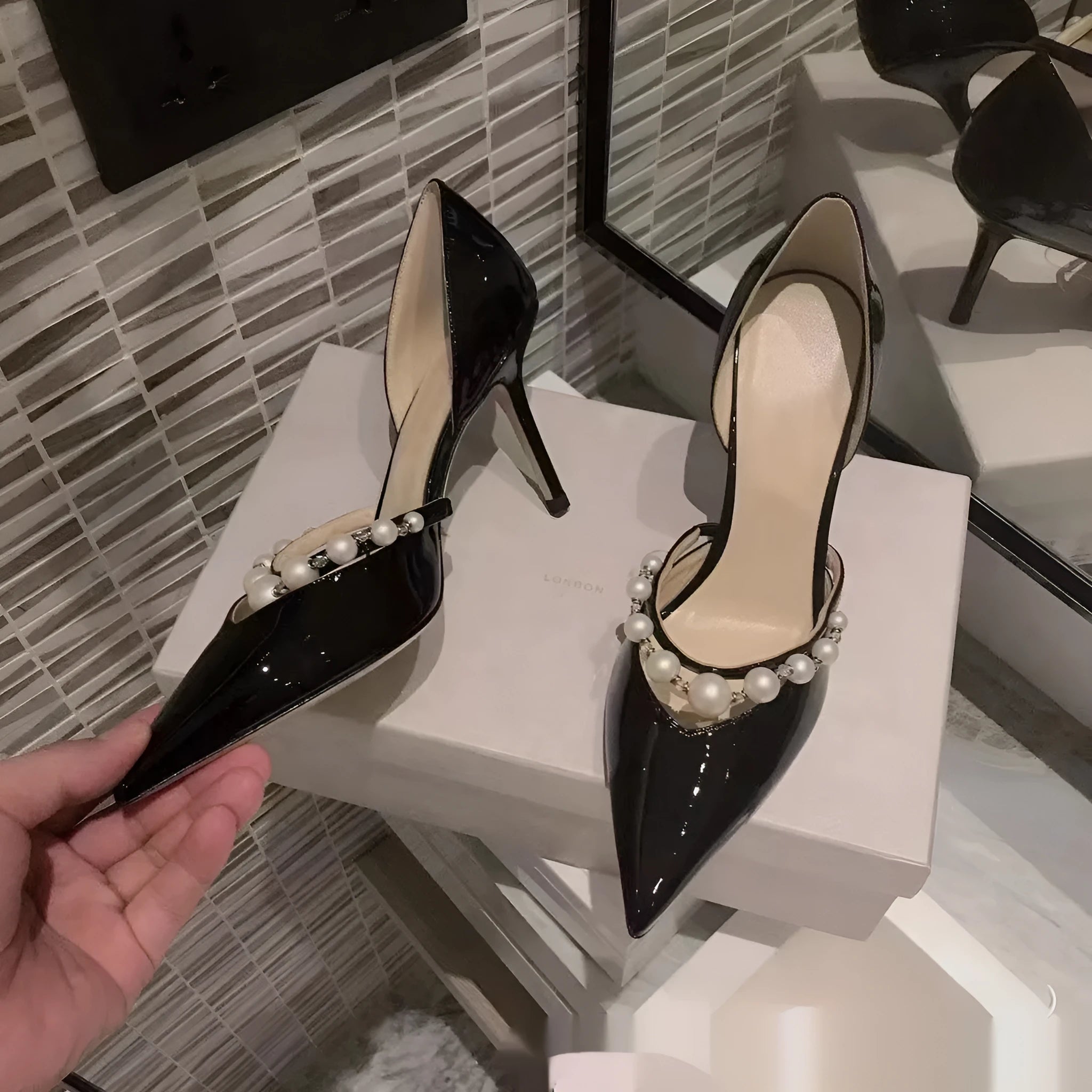 Women's patent leather pointed toe high heels with pearl accents on stiletto heel