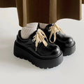 Matte black women's lace-up boots with thick rubber sole and English muffin heel