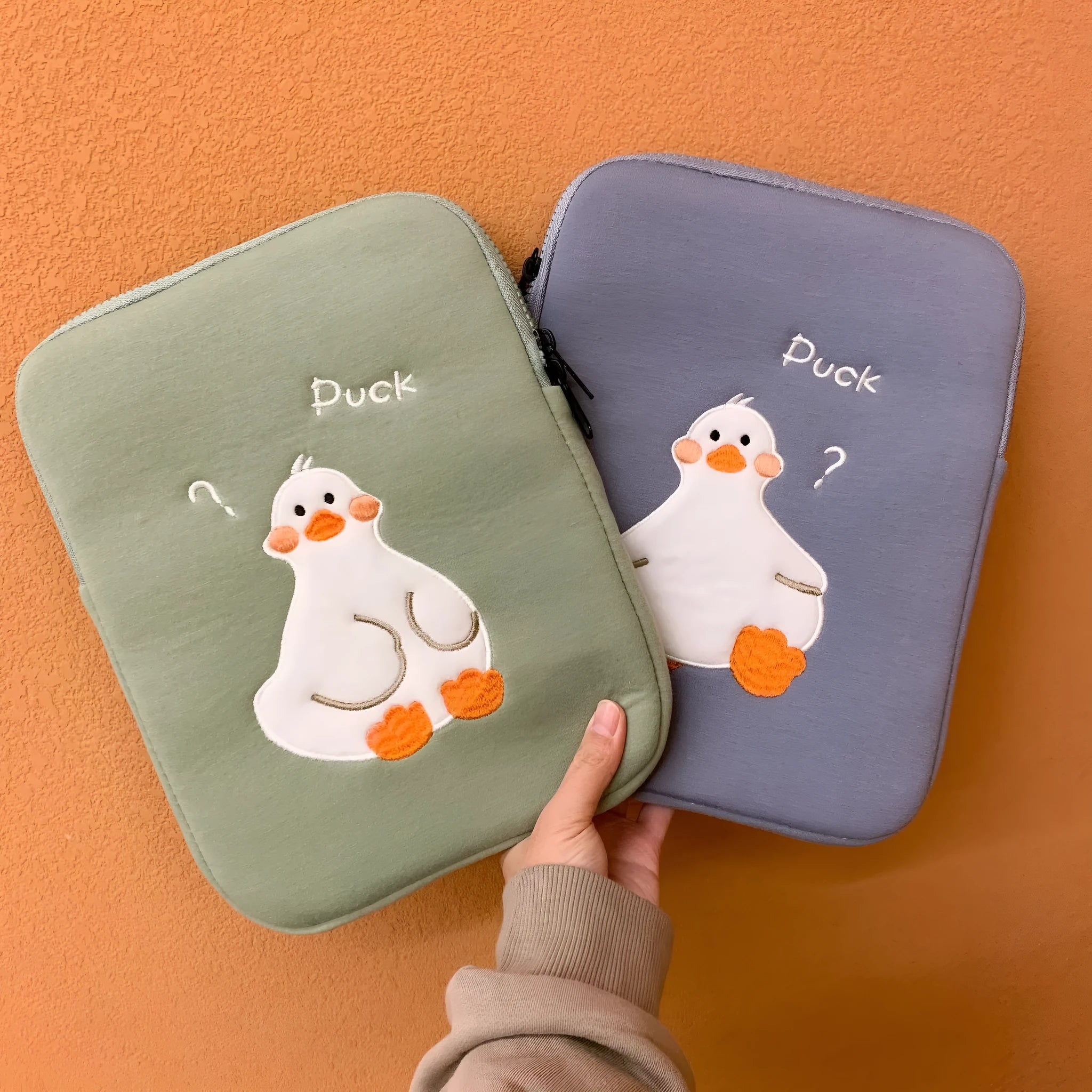 Blue cotton tablet case with embroidered cartoon duck design and zipper closure.