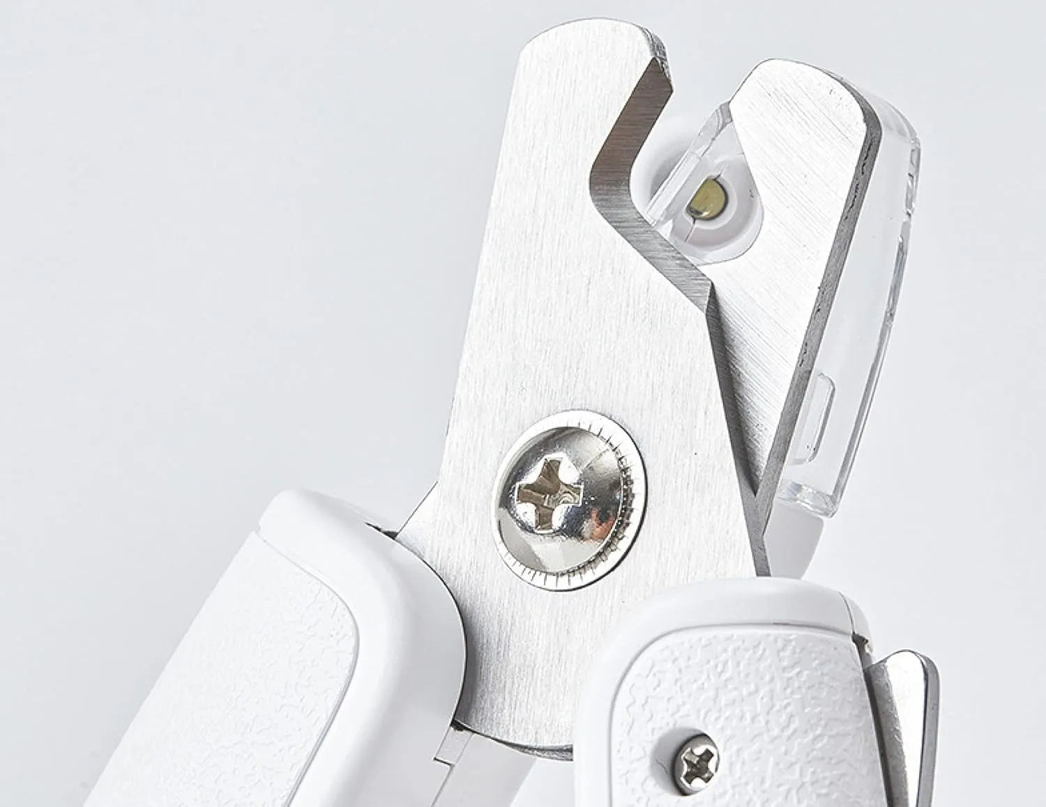 White pet nail clippers with LED light on blade and transparent anti-splash guard, shown with a nail file.