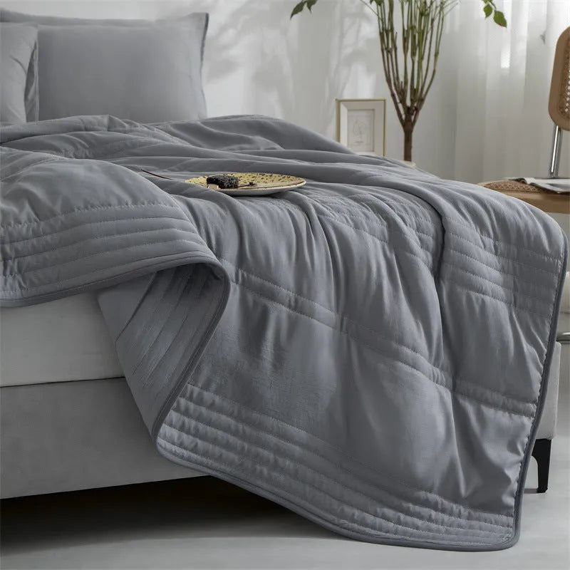 Pure colour seersucker cooling air-conditioning quilt laid flat on a bed