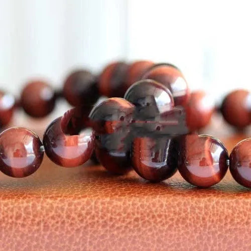 Red Tigereye wood alexandrite hand bracelet showing lightning cat's eye pattern with geometric ethnic style design