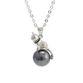 Close-up of a delicate sterling silver cat pendant on a thin clavicle-length chain.