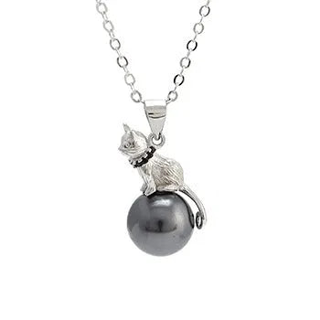 Close-up of a delicate sterling silver cat pendant on a thin clavicle-length chain.