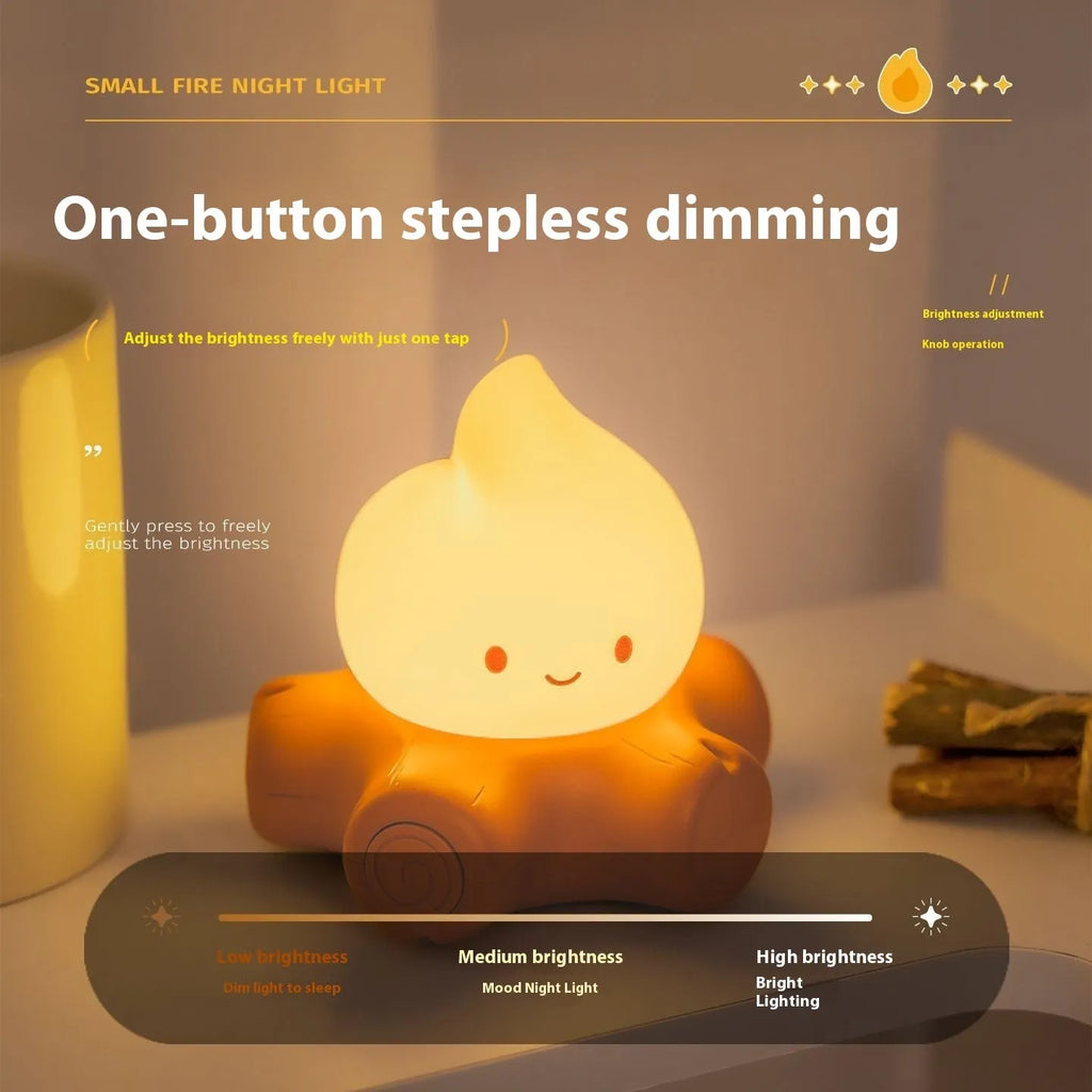 Small yellow silicone night lamp with cartoon fire pile design on a table.