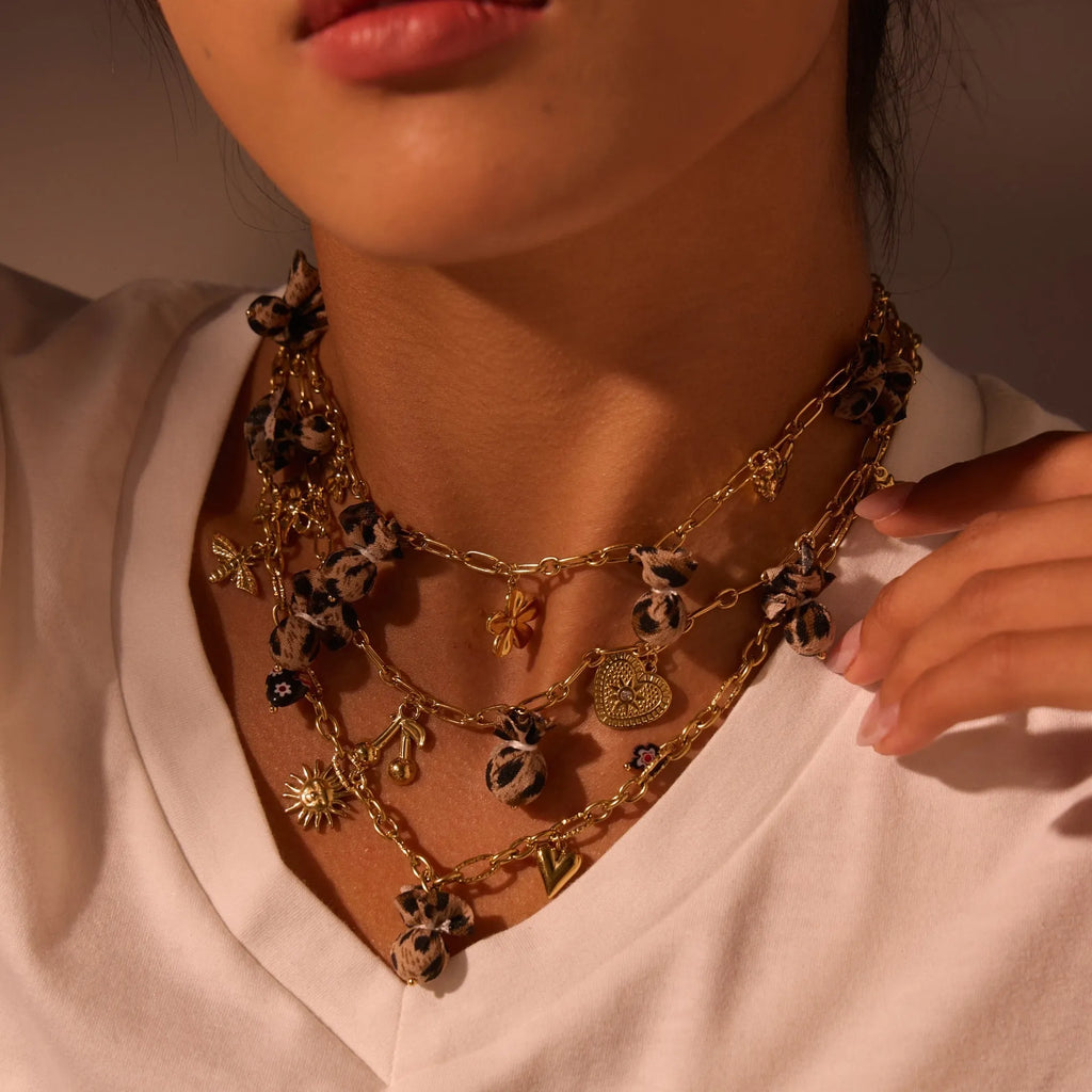 Gold plated stainless steel necklace with geometric leopard, heart, and flowers pendant on adjustable chain