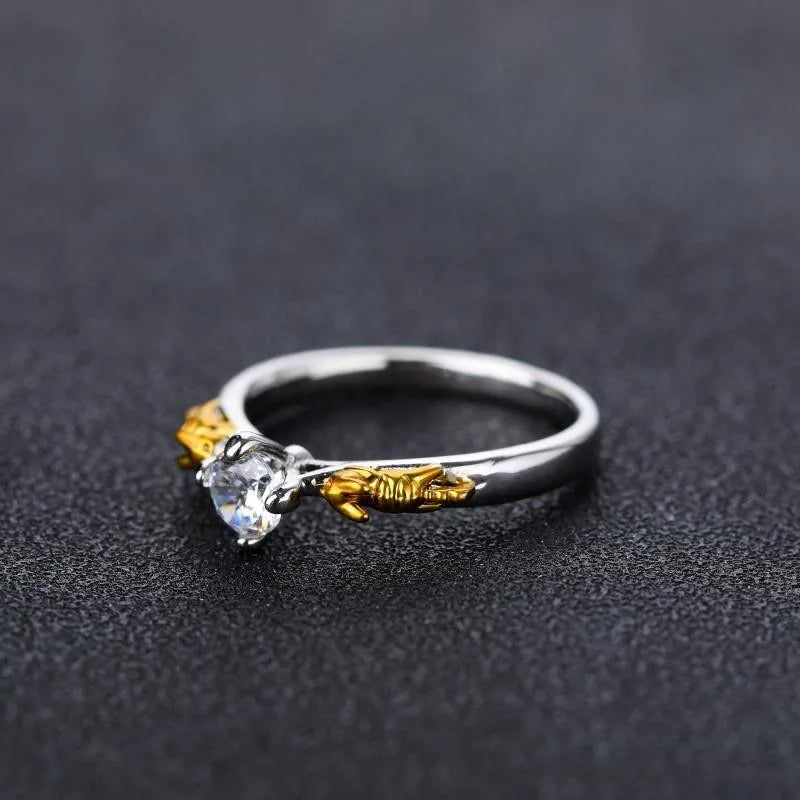 Copper crown design crystal ring in black gold finish on a size chart.
