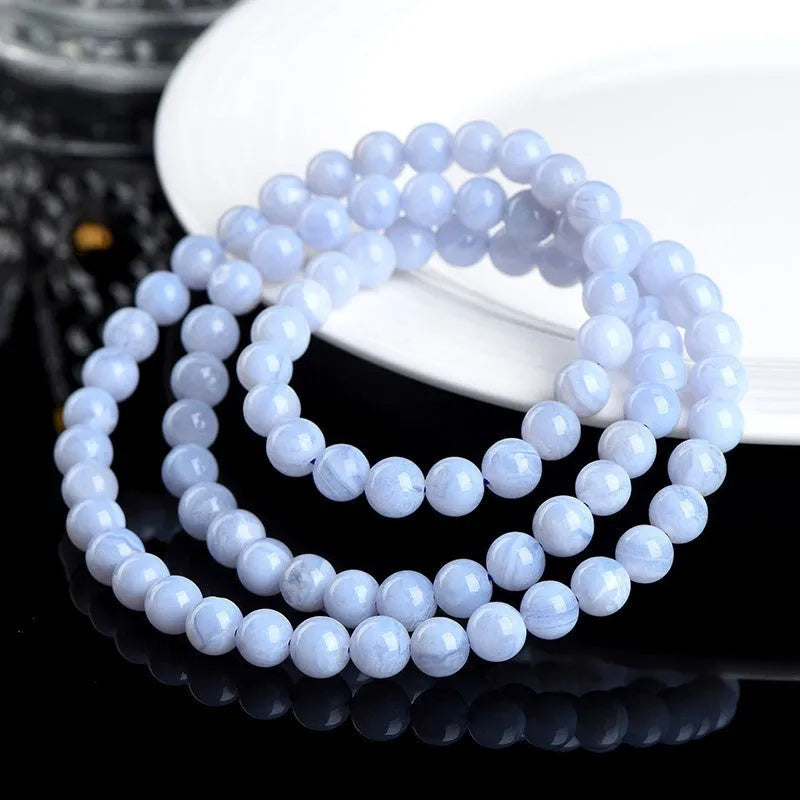 Natural blue agate bracelet showing scattered beads with blue striped pattern and three-circle design